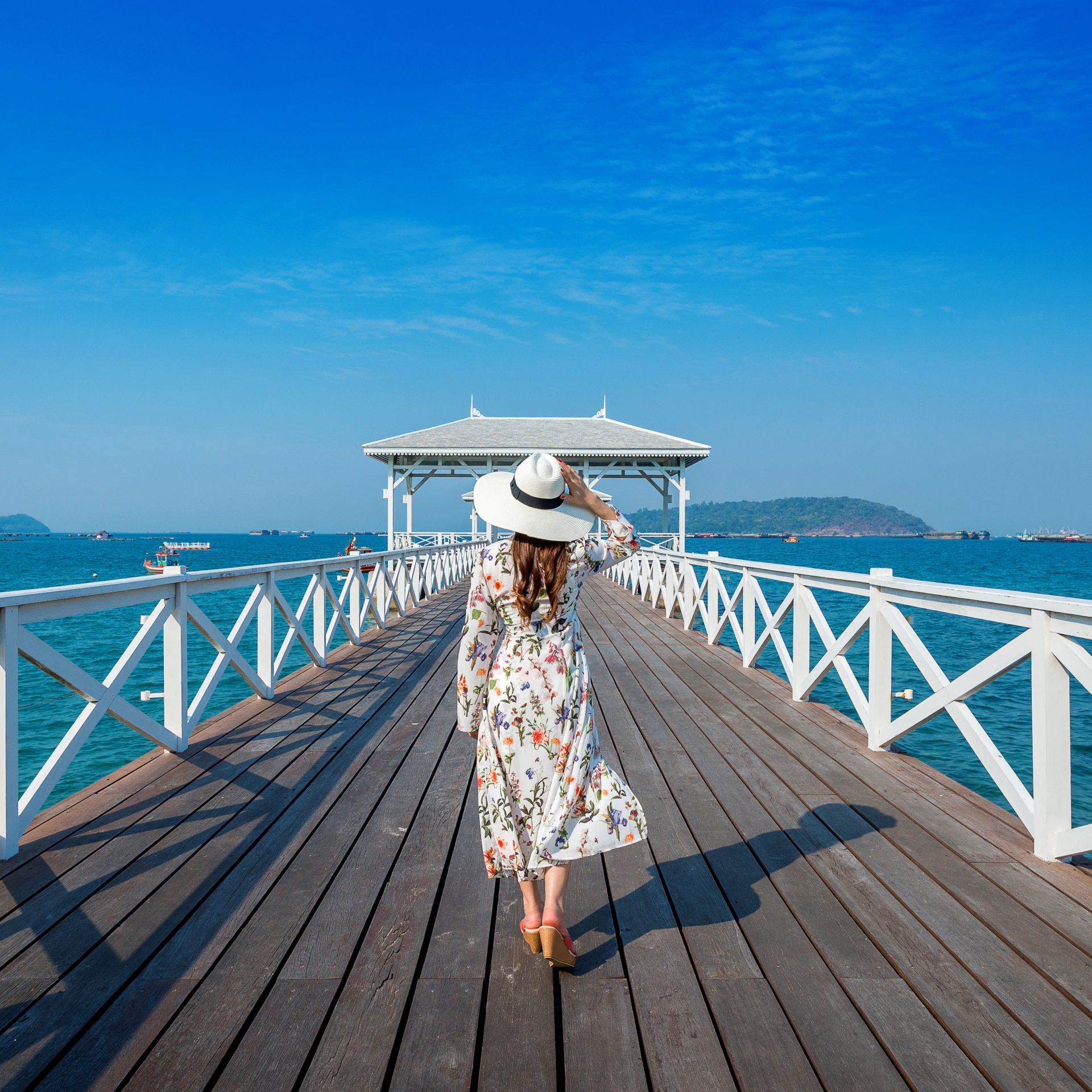 Young woman walking on wooden bridge in Si chang island, Thailan