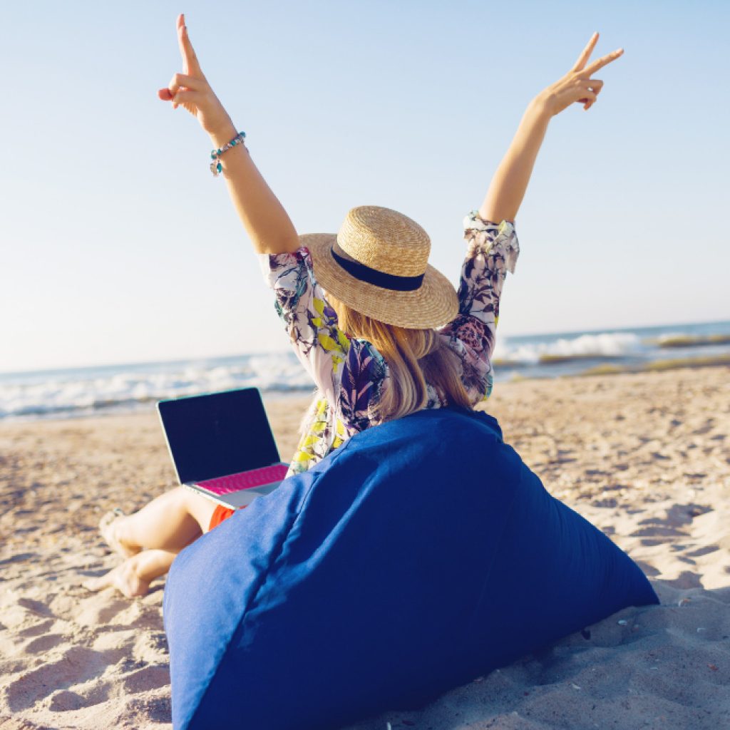 Beautiful young woman working with laptop tropical beach