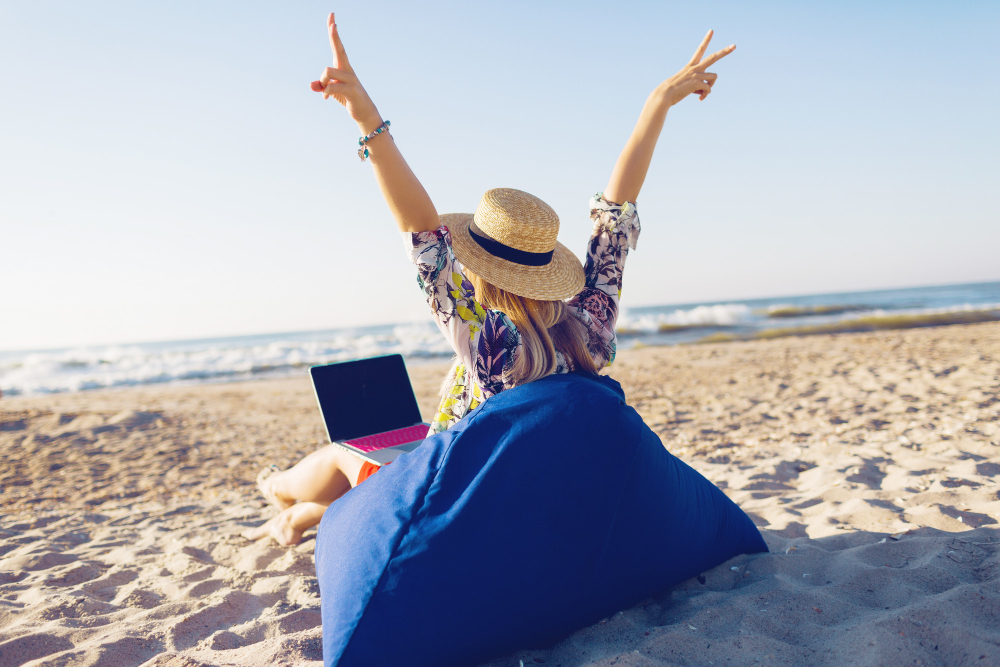 Beautiful young woman working with laptop tropical beach